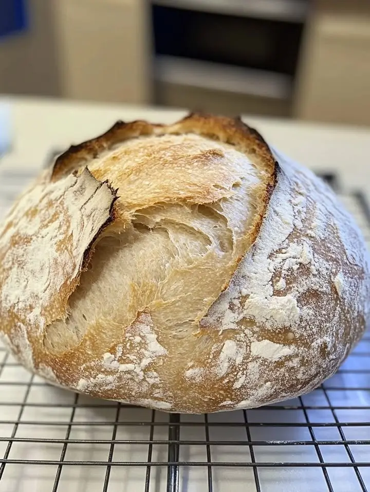 Finished crusty Best Homemade Sourdough Bread Recipe on cooling rack